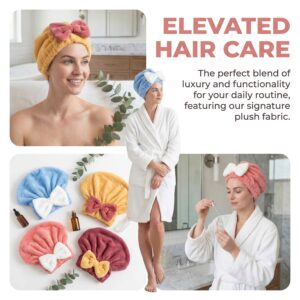 Two women in white robes with plush towel wraps in a bright bathroom spa, one orange towel with pink bow and a blue towel with a white bow nearby. Includes beauty bottles and eucalyptus. Alternative: Spa scene with towel-topped hair, soft lighting, and skincare products on a marble counter.